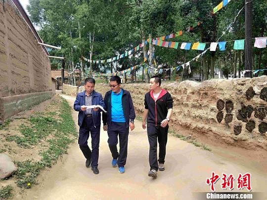 图为&ldquo;第一书记&rdquo;和驻村干部在村里走访。　李隽 摄