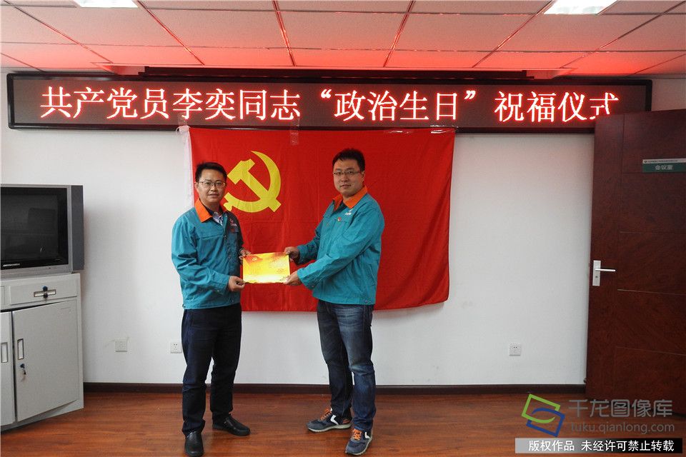 北京城建二机电公司经理何攀（左）向过政治生日的党员李奕颁发生日贺卡