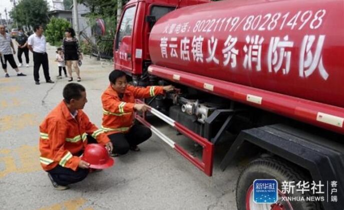 7月10日，霍州营村的村民义务消防员在检查消防车。