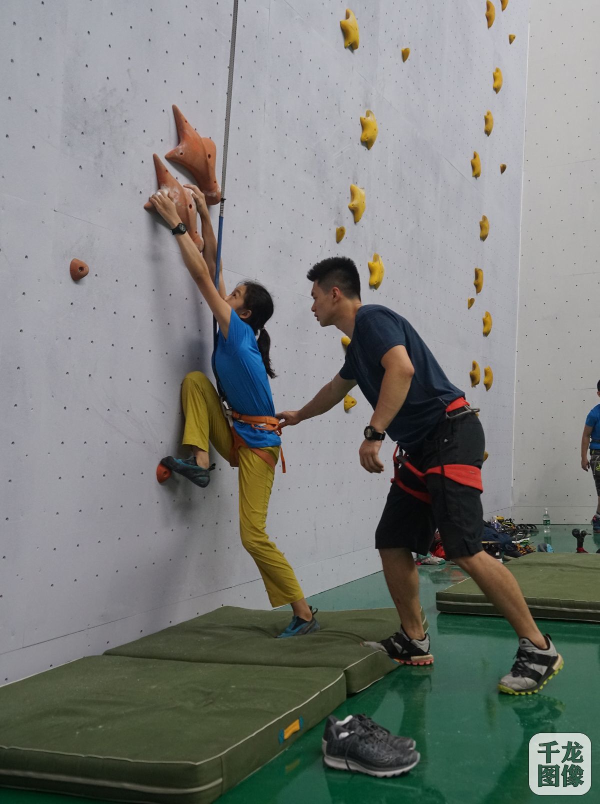 教练指导学员练习速度攀岩起步动作