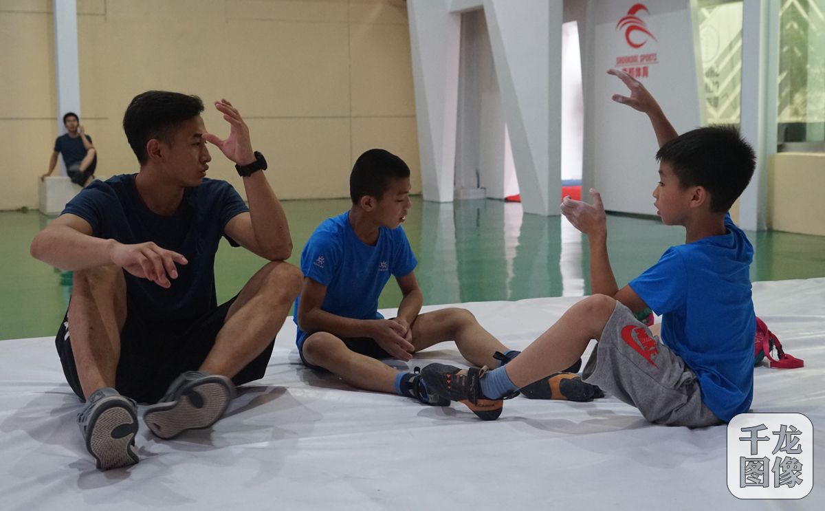 训练间隙，学员与教练沟通攀爬体会