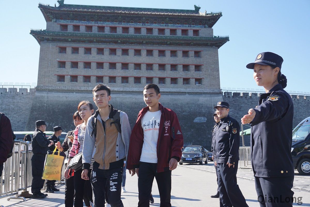 节假日游客出行多少会有一些不便，城管队员不辞辛苦为乘客排忧解难。图为德胜城管执法队队员在德胜门公交枢纽前协助引导乘客通行。