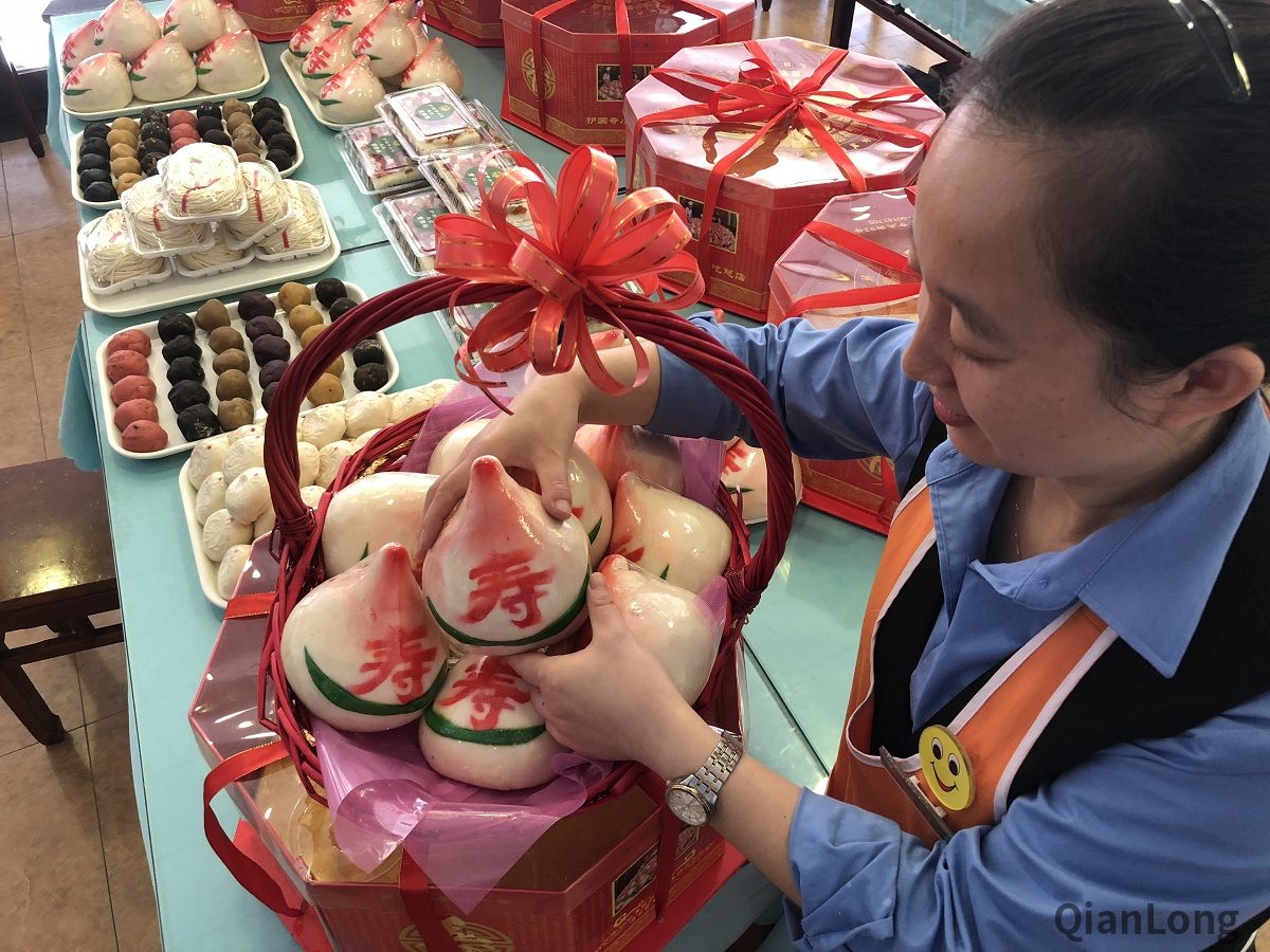 护国寺小吃起源店的工作人员正在摆放寿桃