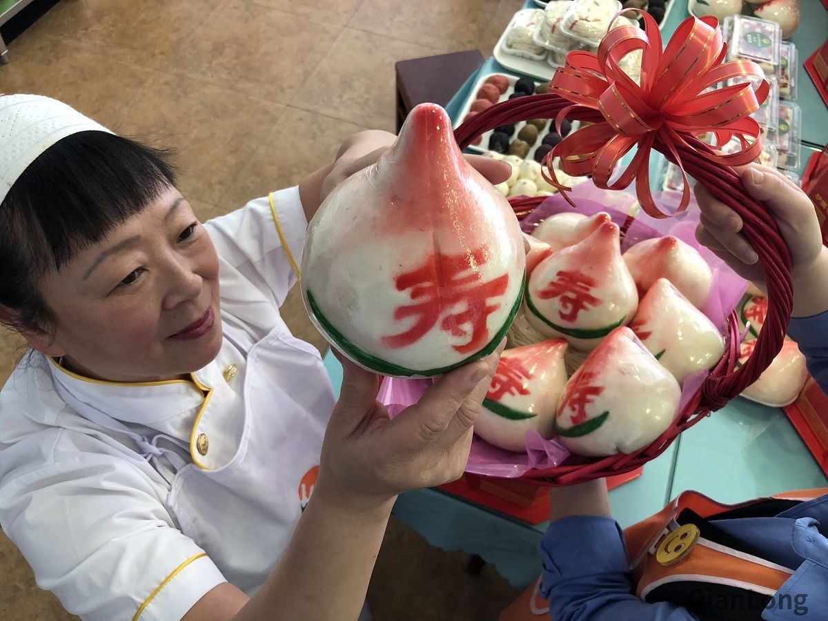 护国寺小吃起源店的工作人员在认真检查每一个寿桃。