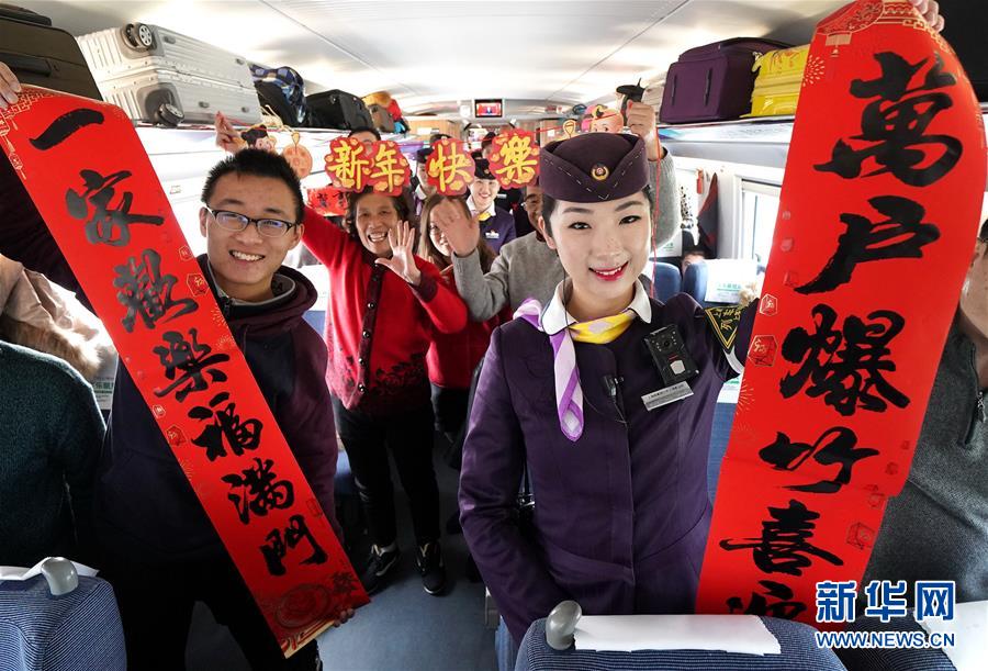 2月5日，G360次高铁乘务员和旅客在车厢内互动合影。