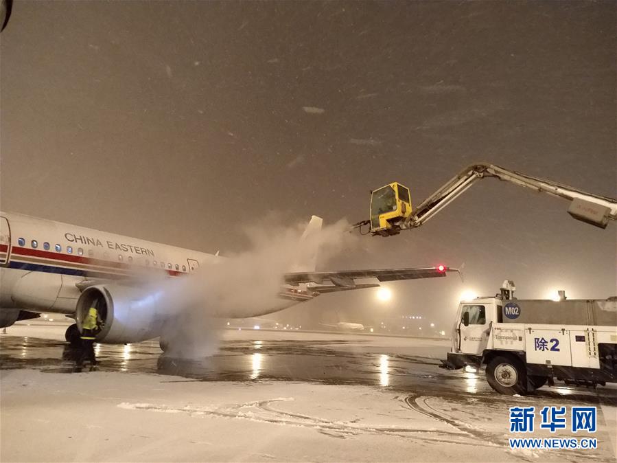 2月6日，北京迎来降雪天气。这是东航北京分公司工作人员在北京首都国际机场清除积雪，保障航班安全。 新华社发（罗兴智 摄）