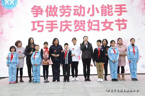 千龙网讯 3月8日，地坛小学举办“争做劳动小能手，巧手庆贺妇女节”活动。同学们为教师、家长、保洁阿姨、食堂阿姨及家政服务阿姨献花，祝福她们节日快乐。