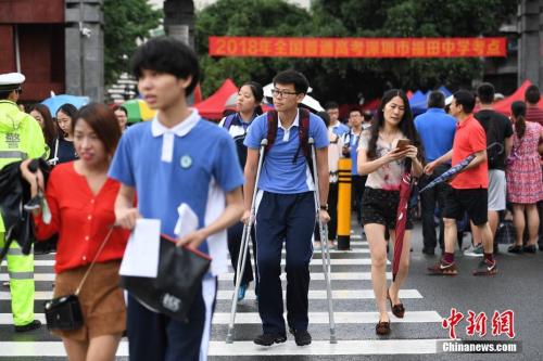 资料图:2018年6月7日,2018年高考进入第一天。图为福田中学考场外,一位高考生带伤上考场。<a target='_blank' href='http://www.chinanews.com/'>中新社</a>记者 陈文 摄 点击进入下一页