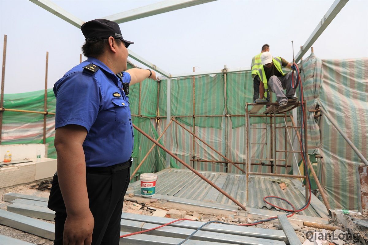 6月19日，新街口玉桃园社区居民发现一处新生楼顶违法建设，社区吹哨，新街口城管执法队第一时间到场，施工人员拒不开门接受检查，派出所到场后，开展对该处违建的取证拆除，认定后将启动快拆机制，当天进行拆除复原。图为新街口街道城管执法队队员当场责令施工人员先行停工。