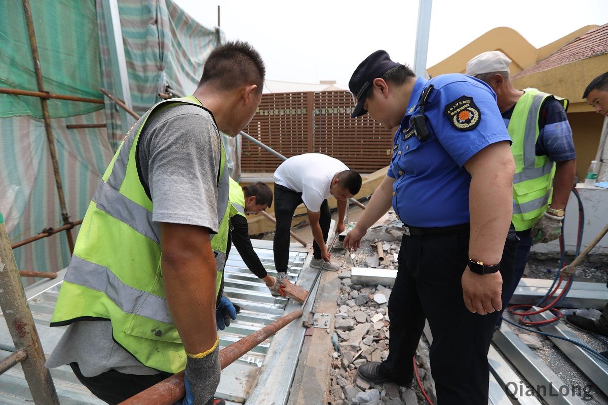 6月19日，新街口玉桃园社区居民发现一处新生楼顶违法建设，社区吹哨，新街口城管执法队第一时间到场，施工人员拒不开门接受检查，派出所到场后，开展对该处违建的取证拆除，认定后将启动快拆机制，当天进行拆除复原。图为新街口街道城管执法队队员协助施工人员开展自拆。