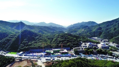 俯瞰八达岭站，站顶正在进行最后的封顶作业。右后侧山顶可以看到长城烽火台。