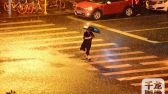 2019年9月10日凌晨，路人在狂风暴雨中的北京街头前行。樊甲山摄 千龙网