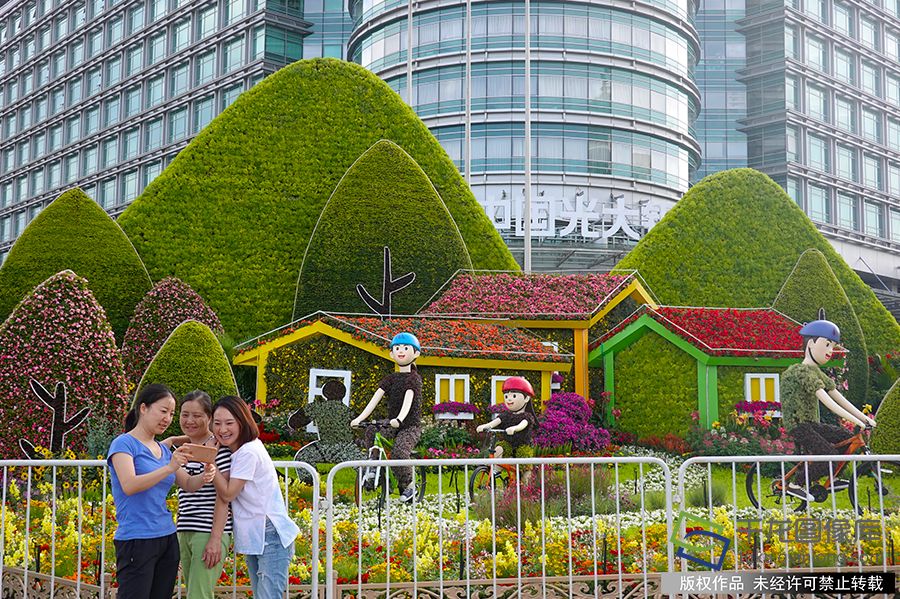 2019年9月16日，随着国庆佳节临近，北京街头主题花坛陆续亮相，吸引市民驻足观赏拍照。赵乃明摄 千龙网发