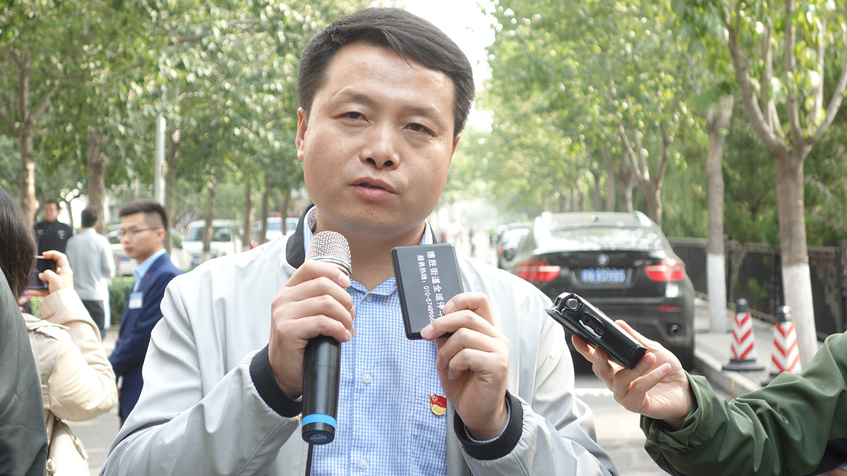 德胜街道城市管理办公室副主任李振波向记者介绍全域停车卡