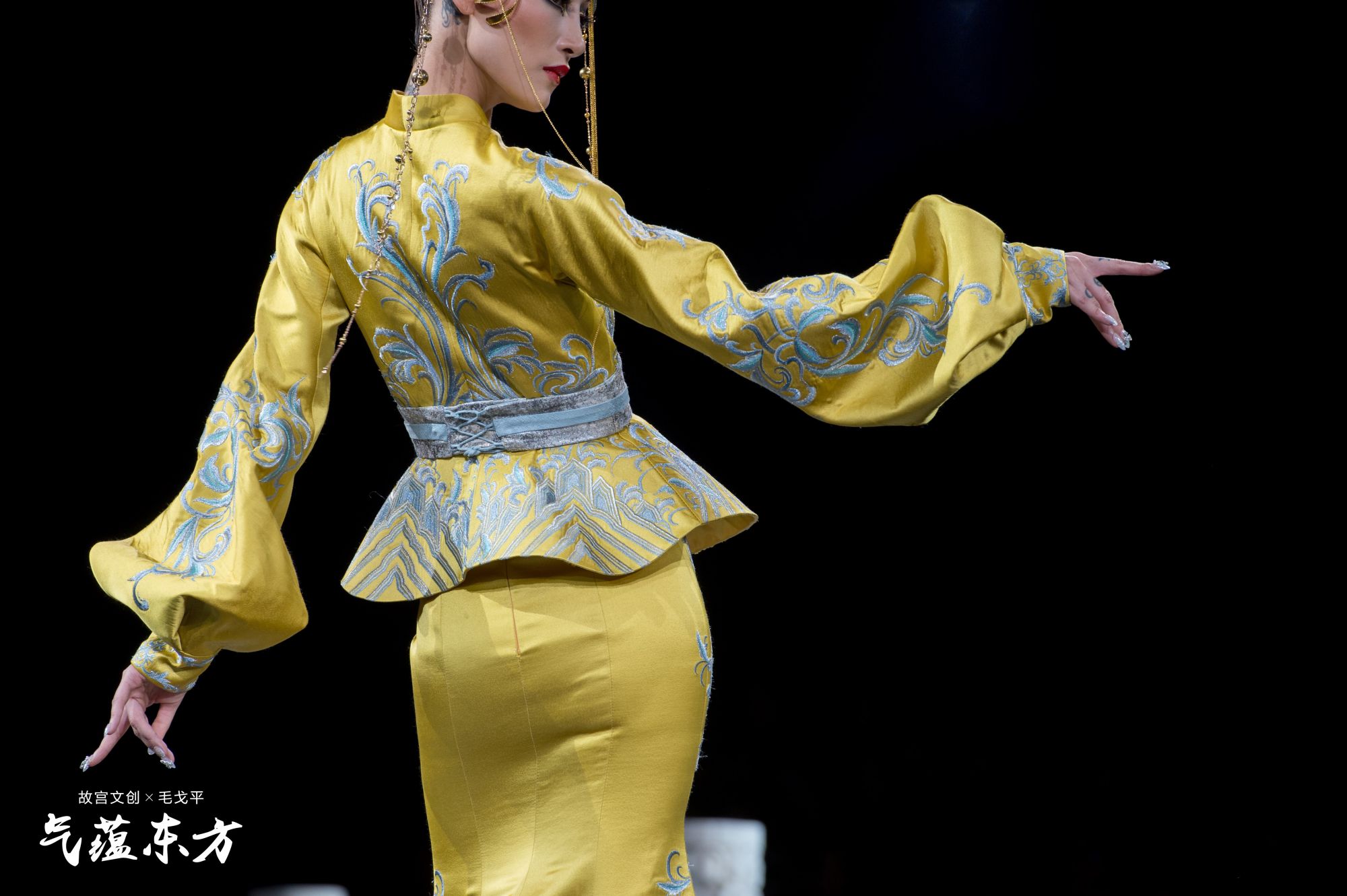 第一系列“庭院鎏金”作品
设计灵感来自中国古代黑漆描金工艺的漆器。该系列妆容富丽、庄严、精致。主色调为神秘的黑、华丽的金。眼影的晕染以飞扬动感的海水江崖纹的波浪形为主，加上黑、蓝的色彩和明丽的金色粘贴，薄妆桃脸，双目两侧点缀缤纷花靥，仿佛唐风盛行的面靥翩然而至，用现代立体化妆手法表现出整体的华美与时尚感。