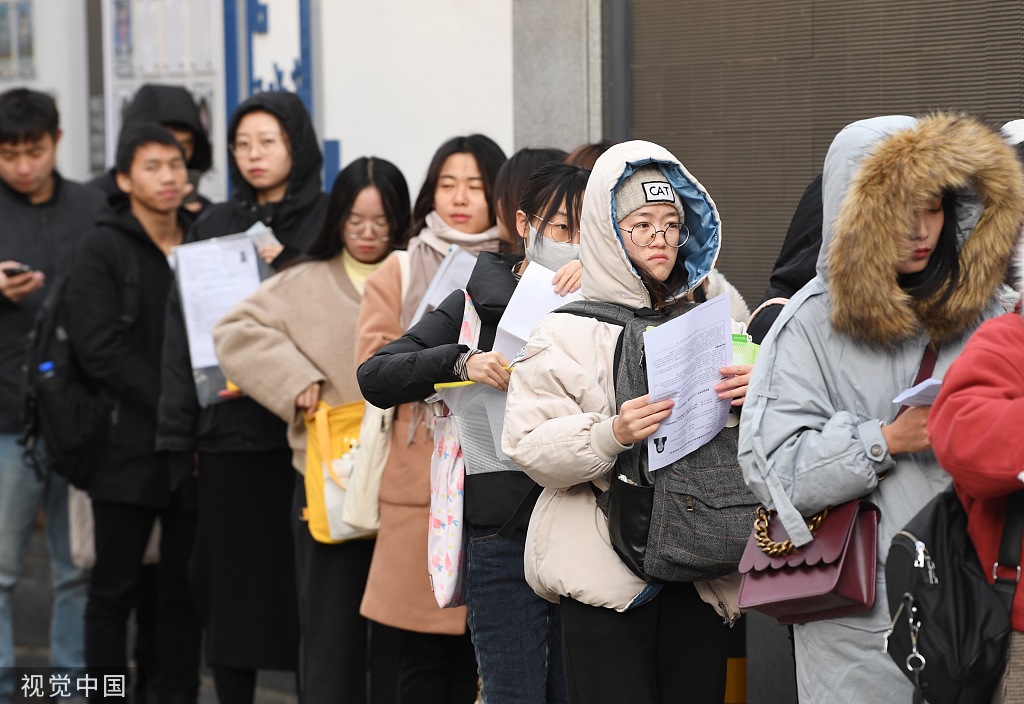 2019年11月24日，北京市对外贸易学校考点外已有一两百考生早早赶来，不少拿着辅导机构派发的复习资料“临阵磨枪”着，包括中央一号文件、乡村振兴、精准扶贫、人工智能等时事热点都被列为重点内容。图片来源：视觉中国
