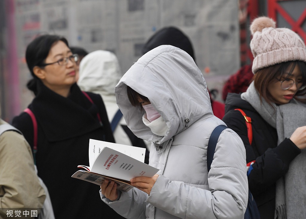 2019年11月24日，北京市对外贸易学校考点外已有一两百考生早早赶来，不少拿着辅导机构派发的复习资料“临阵磨枪”着，包括中央一号文件、乡村振兴、精准扶贫、人工智能等时事热点都被列为重点内容。图片来源：视觉中国
