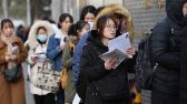 2019年11月24日，北京市对外贸易学校考点外已有一两百考生早早赶来，不少拿着辅导机构派发的复习资料“临阵磨枪”着，包括中央一号文件、乡村振兴、精准扶贫、人工智能等时事热点都被列为重点内容。图片来源：视觉中国
