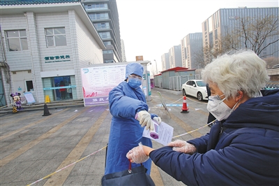 2月12日，德胜社区卫生服务中心，工作人员为一位老人测体温。