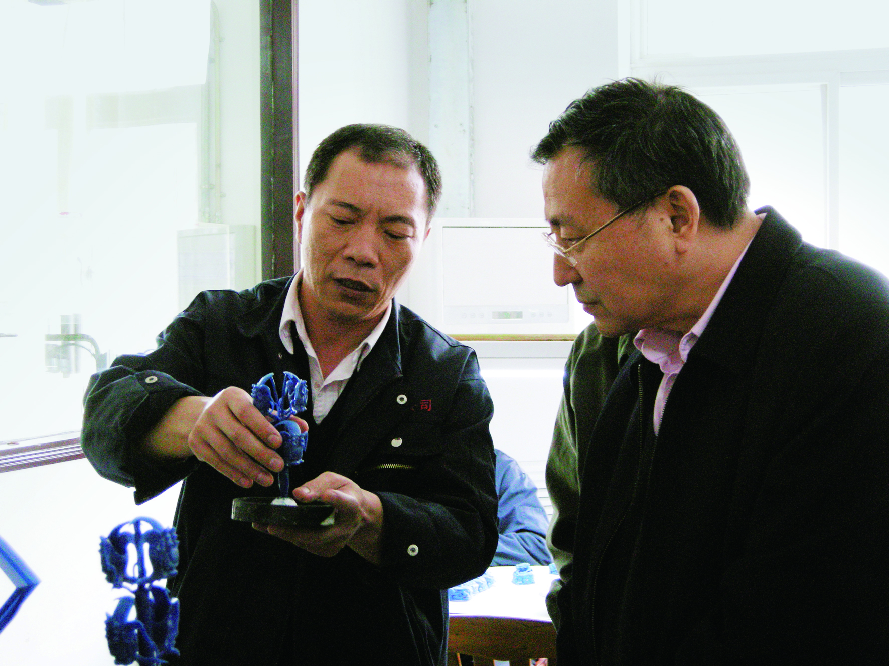 5、向原集团公司董事长郭泰来介绍奥运徽宝铸蜡工艺（左一）