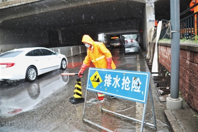 昨日，回龙观育知东路铁路桥下，排水集团工作人员正在进行排水作业。 新京报记者 王飞 摄