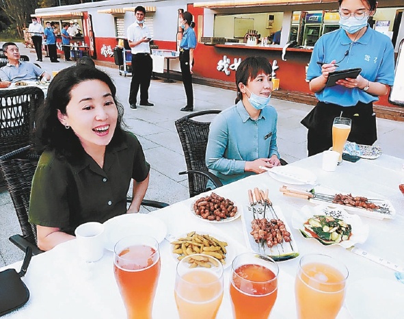 随着疫情防控形势向好，京城的户外餐饮按下“重启键”。在友谊宾馆啤酒花园，许多市民在凉爽的晚风里户外就餐、享受美食。 本报记者 阎彤摄