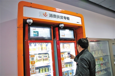 1月18日，2020年迎新春北京消费扶贫年货大集在北京消费扶贫双创中心进行，市民在消费扶贫专柜前扫码购物。新京报记者 郑新洽 摄