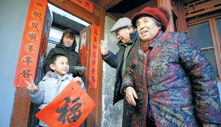 朱红和李豫做好蛋卷，写好福字，送给街坊邻里。本报记者 武亦彬摄