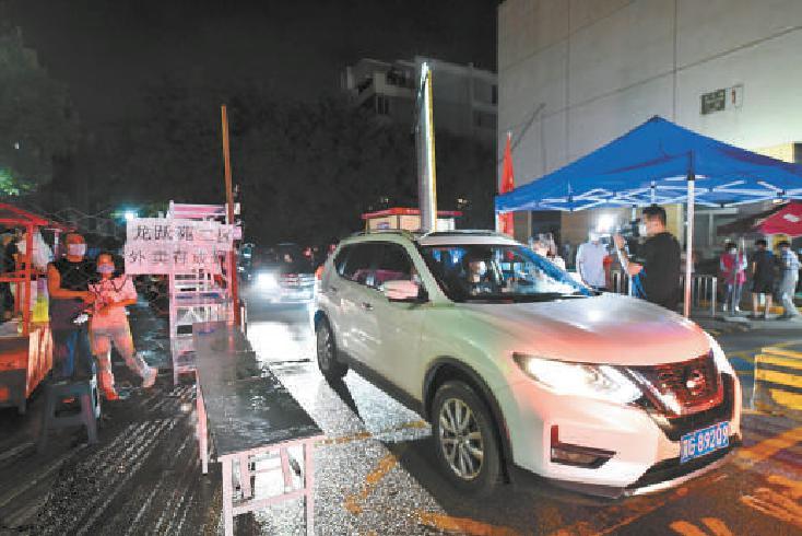 今天零时，昌平区龙跃苑二区解封，车辆驶出小区。本报记者 邓伟摄