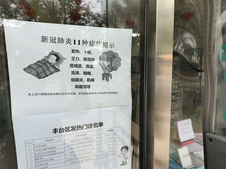 药店门口张贴着新冠肺炎11种症状提示及发热门诊就诊医院清单。