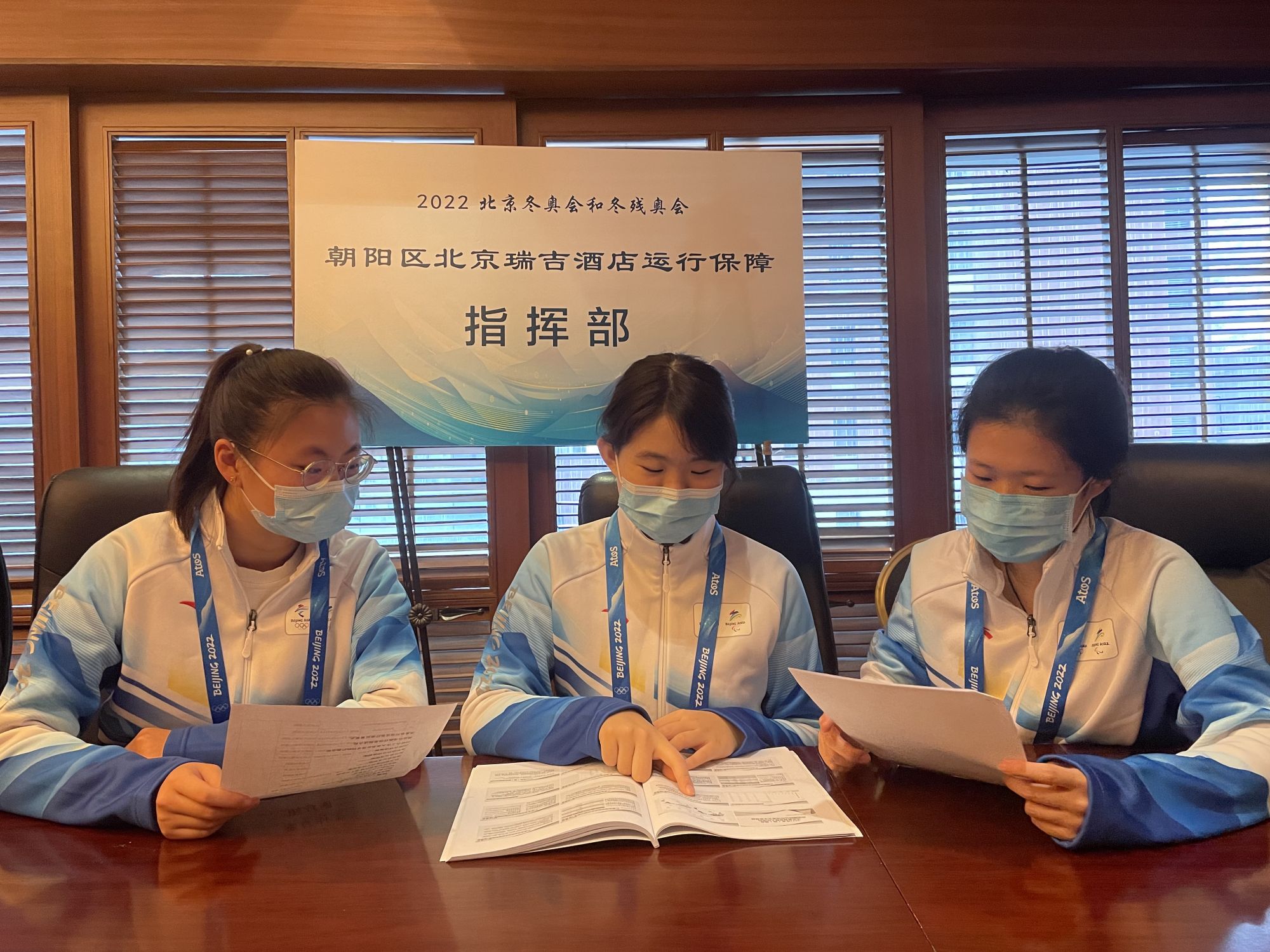 北京瑞吉酒店三名志愿者查看文件,校对重要会议记录和每日需要整理上报的信息。