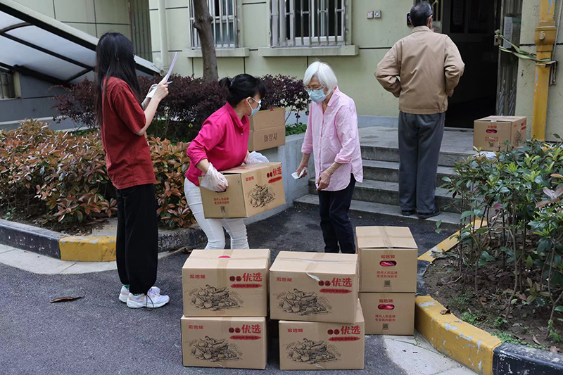 年轻居民为老龄邻居搬运物资    摄影记者/任玉明