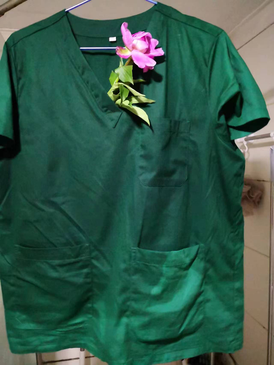 聂理会在汗水湿透的衣服上插着邻居送的牡丹花。受访者供图 聂理会在汗水湿透的衣服上插着邻居送的牡丹花。受访者供图