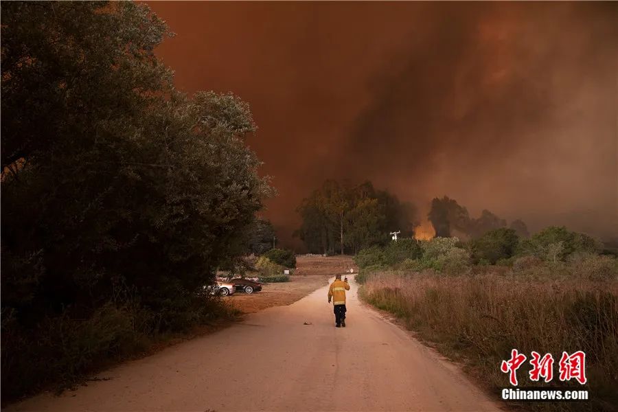 2020年8月，多场山火在美国加利福尼亚州旧金山湾区土地上燃烧，由22起火灾组成的大火至少燃烧了4000公顷土地，迫使22000多人疏散。图为一名参与灭火的人员用对讲机与同伴沟通。<a target=