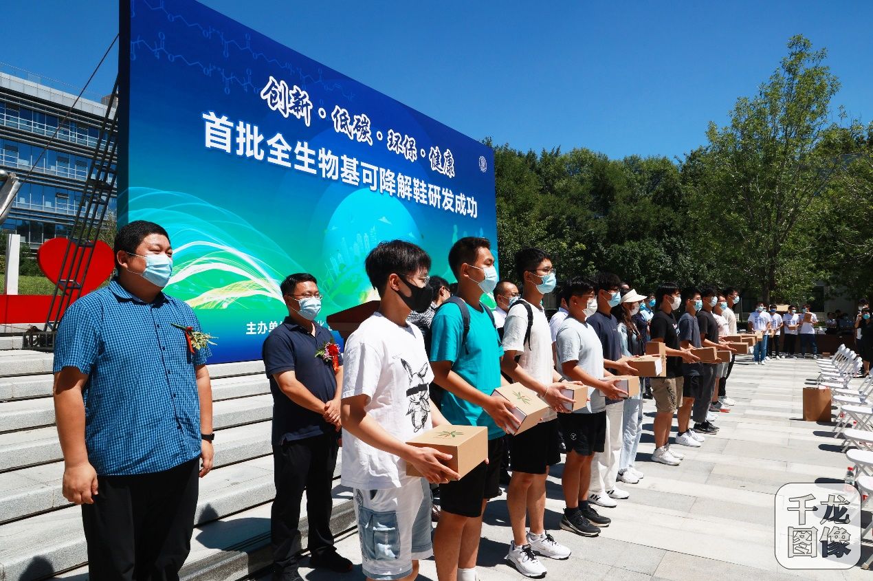 图为与会嘉宾为北化学子赠送全生物基可降解鞋，北京化工大学供图