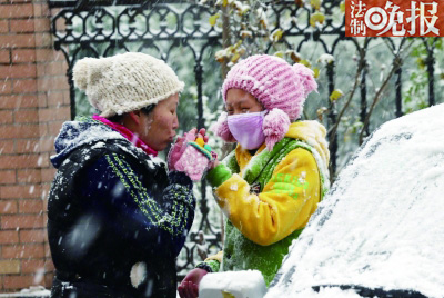 在通州某小区,母女俩玩雪后哈气暖手摄/记者 黑克北四环某小区,市民带