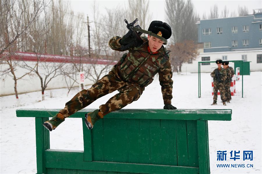 1月12日,武警新疆伊犁边防支队老兵在训练场上给新兵示范障碍战术跃进