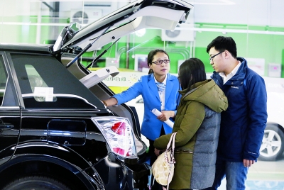 上周六,在联合电动长楹龙湖店,明星销售员王亚娜向顾客介绍新能源汽车