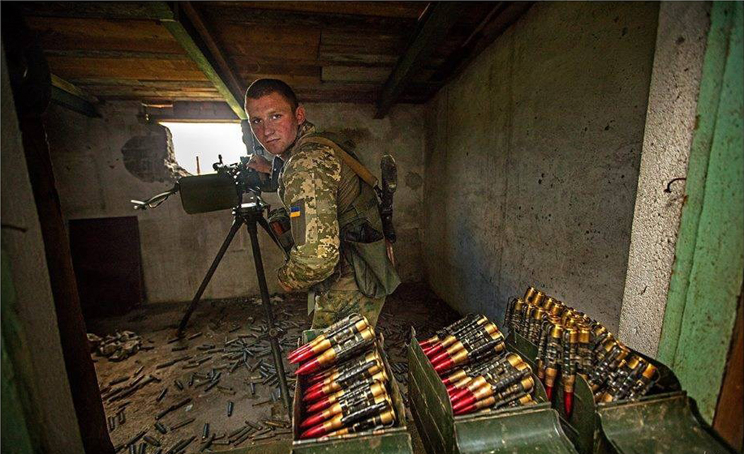 在掩体中作战的乌军机枪手,可见满装的弹药箱.