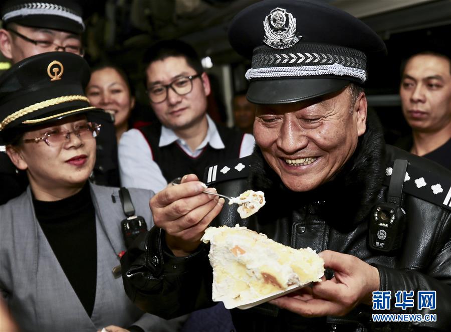 在z42次列车上,周小平(前右)品尝同事送来的蛋糕(1月26日摄).