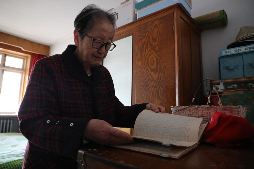 范木兰老人整理收据和相关记录。曹建雄摄