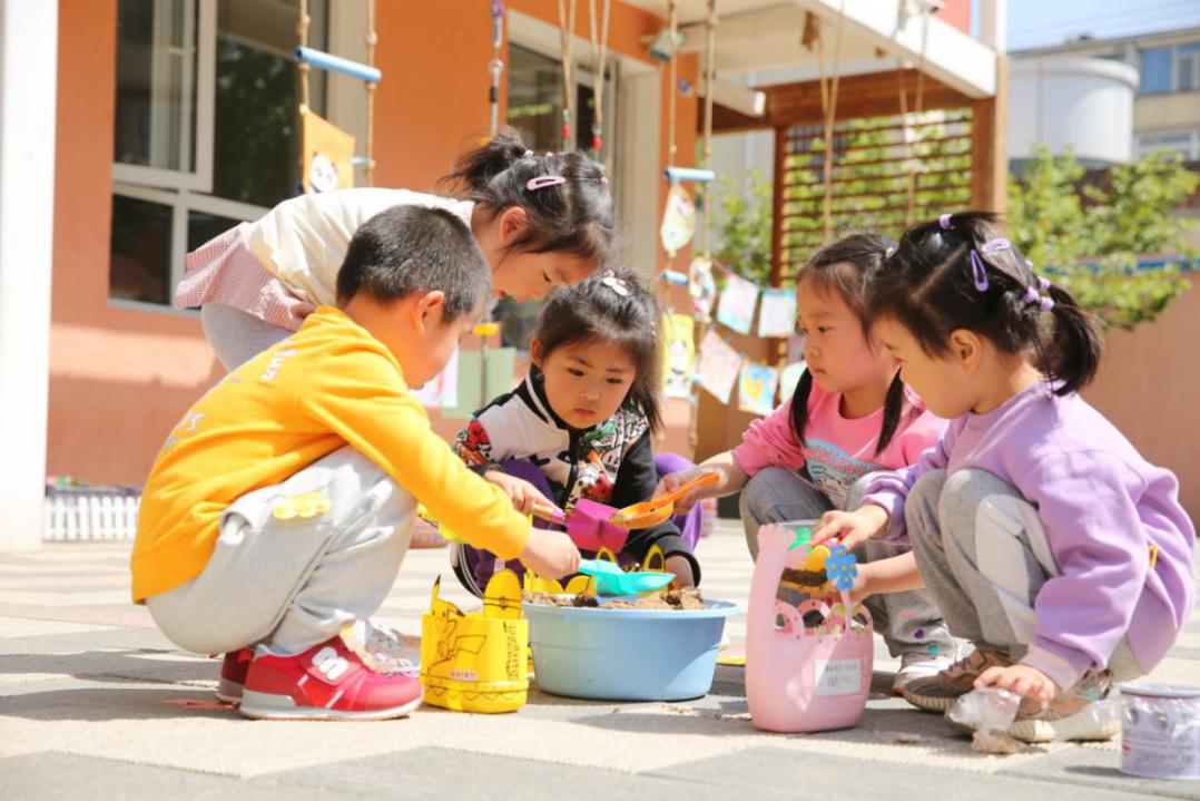 孩子们正在培土，为“绿色种植”做准备（学校供图）