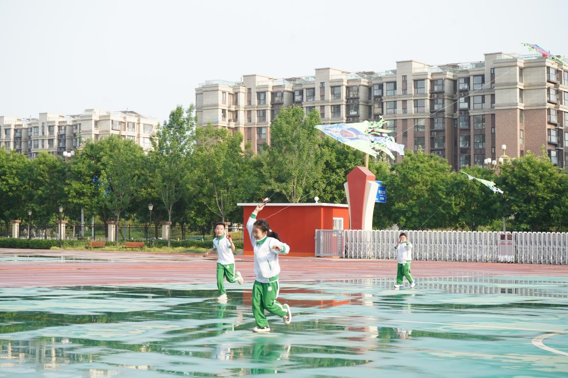 孩子们在操场上放飞风筝。学校供图