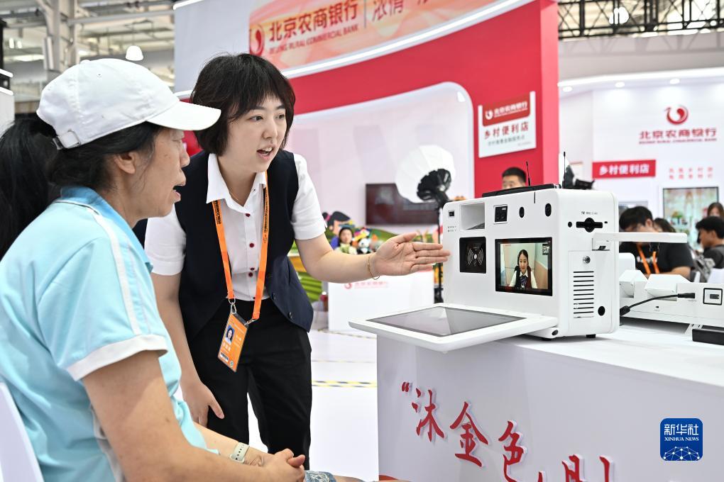 9月3日，首钢园北京农商银行展台的工作人员向参观者介绍一款自主设计的视频银行，该设备对特殊人群客户到网点难、无法临柜核实身份等金融服务痛点提供了有效的解决方案。新华社记者 李鑫 摄
