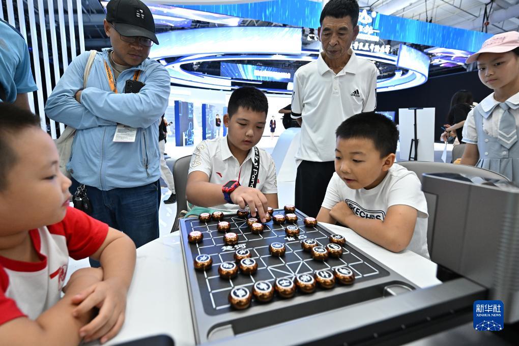 9月3日，小朋友在首钢园内与一款象棋机器人对弈。新华社记者 李鑫 摄