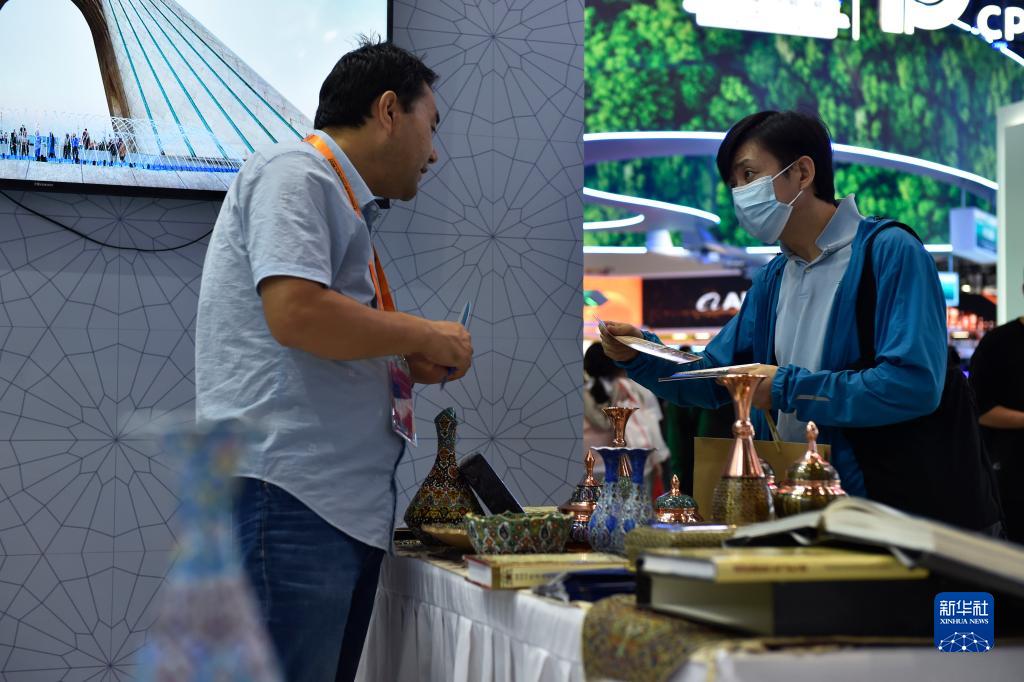 9月4日，在服贸会国家会议中心的伊朗展台，观众在了解伊朗手工艺品。新华社记者 刘岭逸 摄
