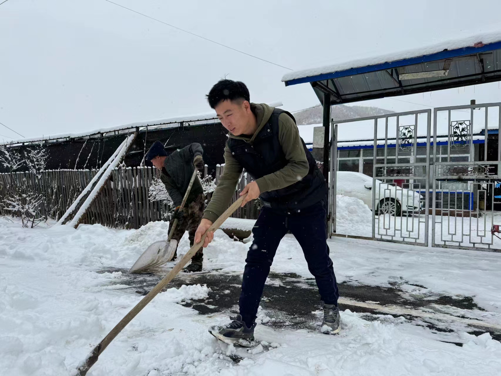 李建军父子俩在清扫家门口的积雪。人民网记者 曾帆摄