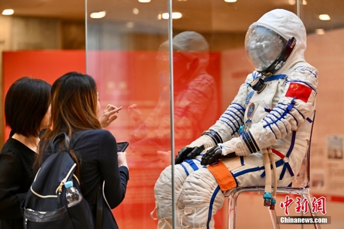 11月30日下午，由香港特区政府和中国载人航天工程办公室联合主办、康乐及文化事务署筹划的&ldquo;中国载人航天工程展&rdquo;在香港科学馆举行新闻界预展。展出超过25组展品，包括神舟飞船返回舱、舱内航天服、中国空间站模型、多支火箭的模型如长征二号F、长征七号、长征五号B运载火箭，以及新一代载人飞船和月面着陆器的模型，这是首次面向香港社会全面系统展示载人航天工程发展历程和建设成就。图为现场人士观看舱内航天服。中新社记者 李志华 摄