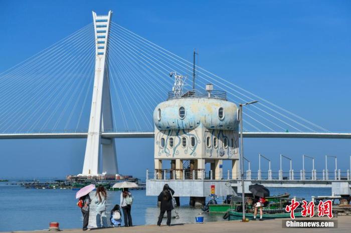 图为游客在文昌铺前渔港游玩。<a target=