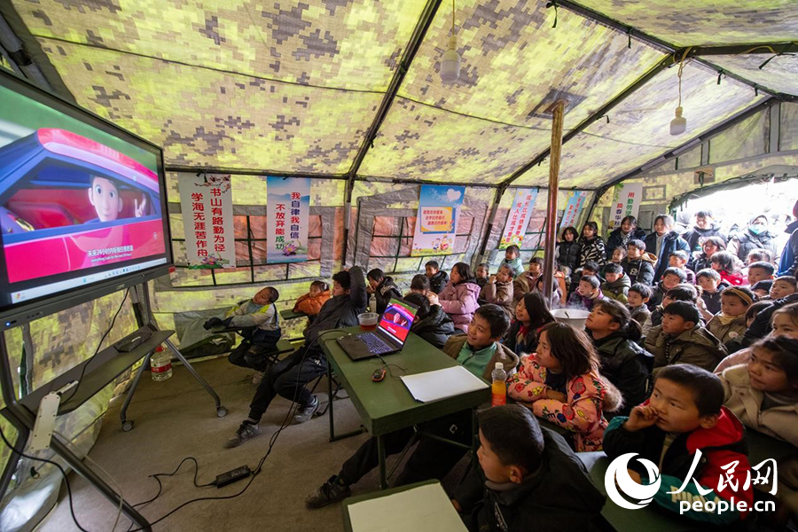 12月22日，在积石山县大河家镇大河村安置点，陆军76集团军某旅搭建的&ldquo;临时学校&rdquo;内，小朋友正在看动画片。人民网记者 翁奇羽摄